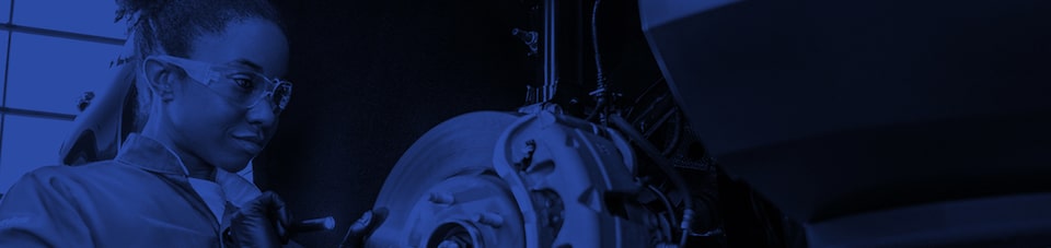 A GM automotive technician performs maintenance on a vehicle.