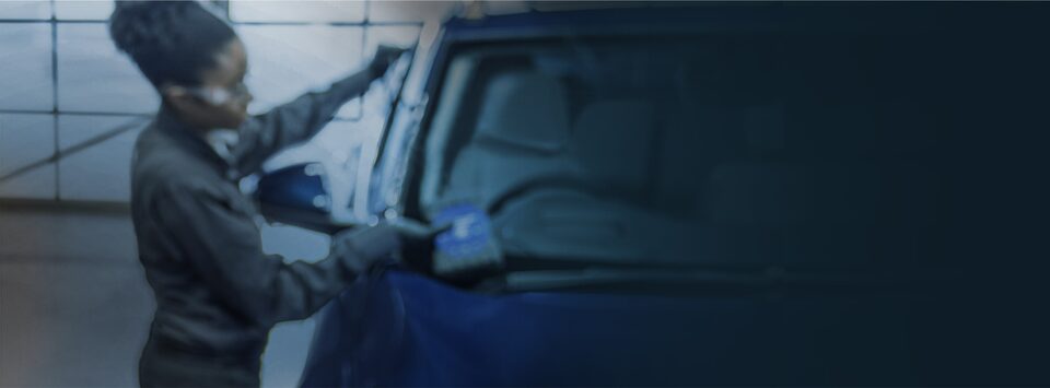 A female Automotive Service Educational Program student performs maintenance on a vehicle.