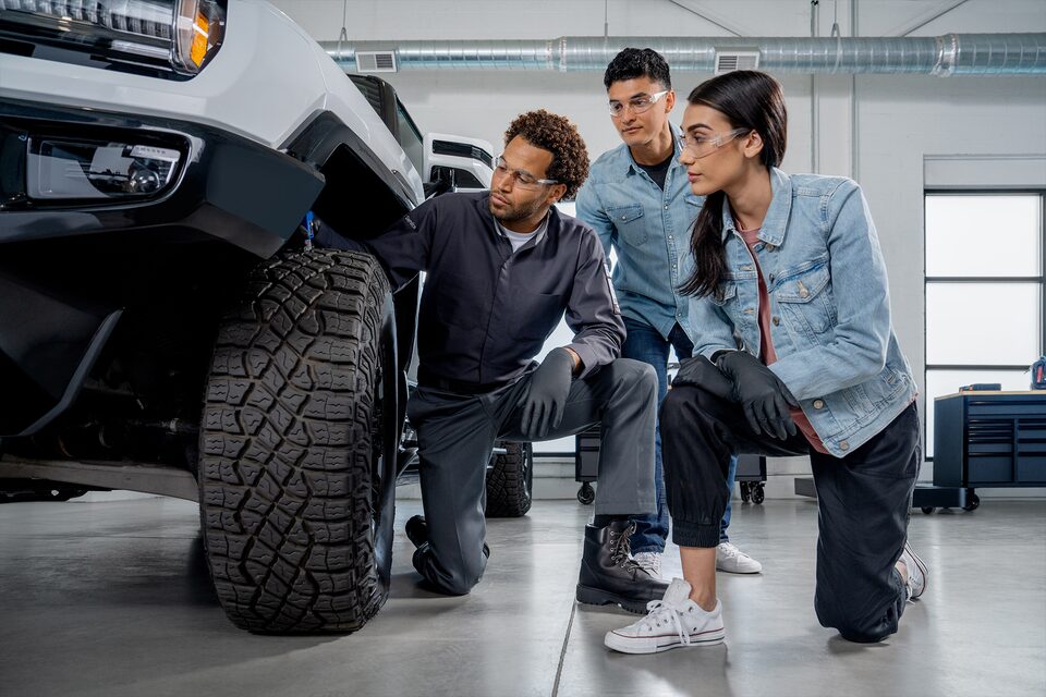 A male Automotive Service Educational Program student performs maintenance on a vehicle.